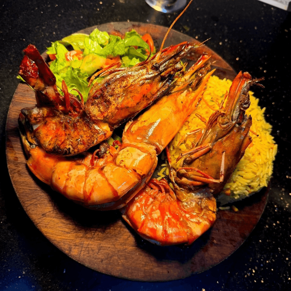Grilled Jumbo Prawns paired with fried yam or mini jollof rice and salad